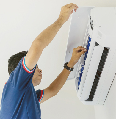 A technician servicing an air conditioning unit