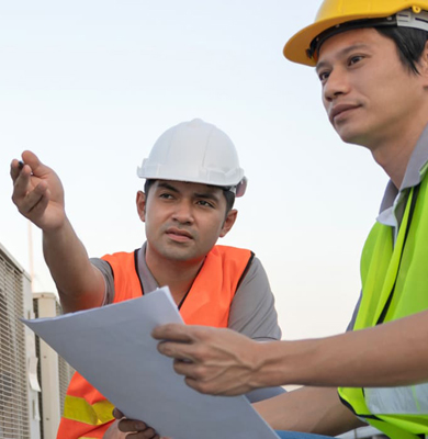 Technicians discussing air conditioning units while on a rooftop