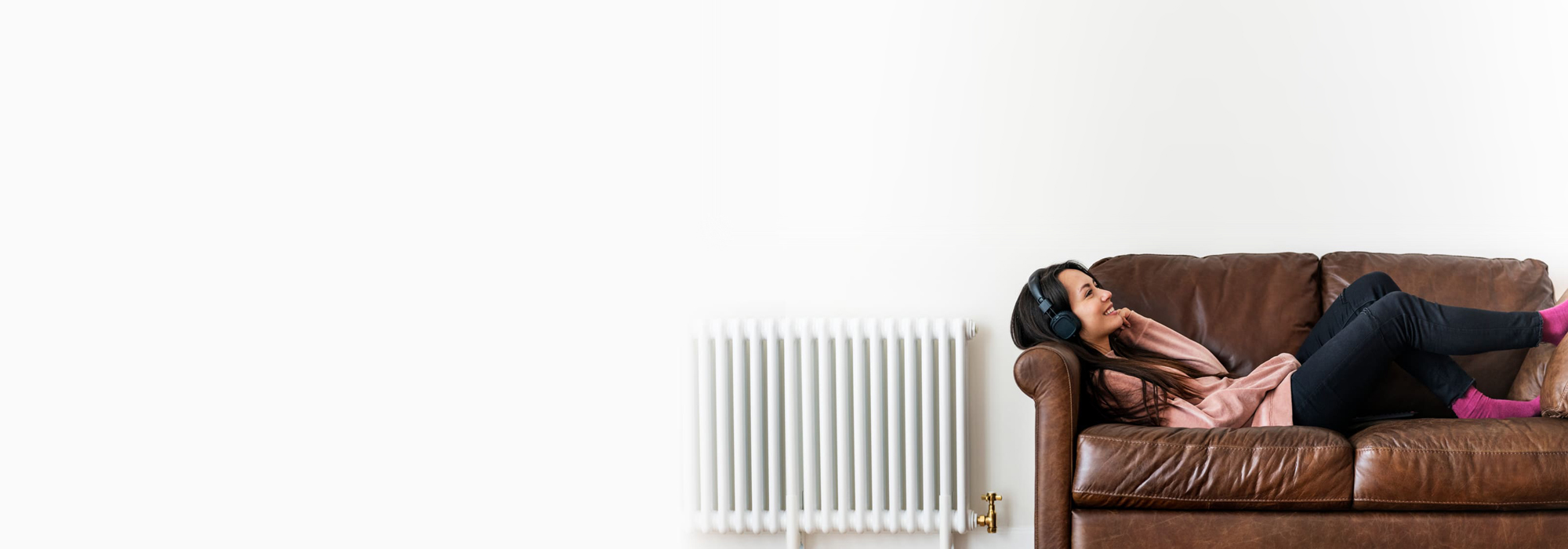 Woman reclines on her sofa while engaged in a phone conversation