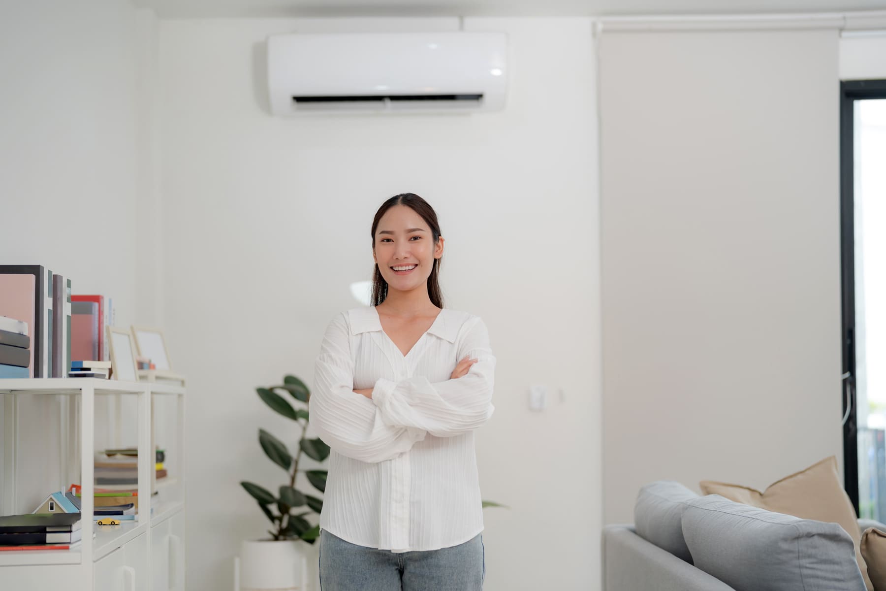 Woman in living-room with air-conditioner unit on the wall